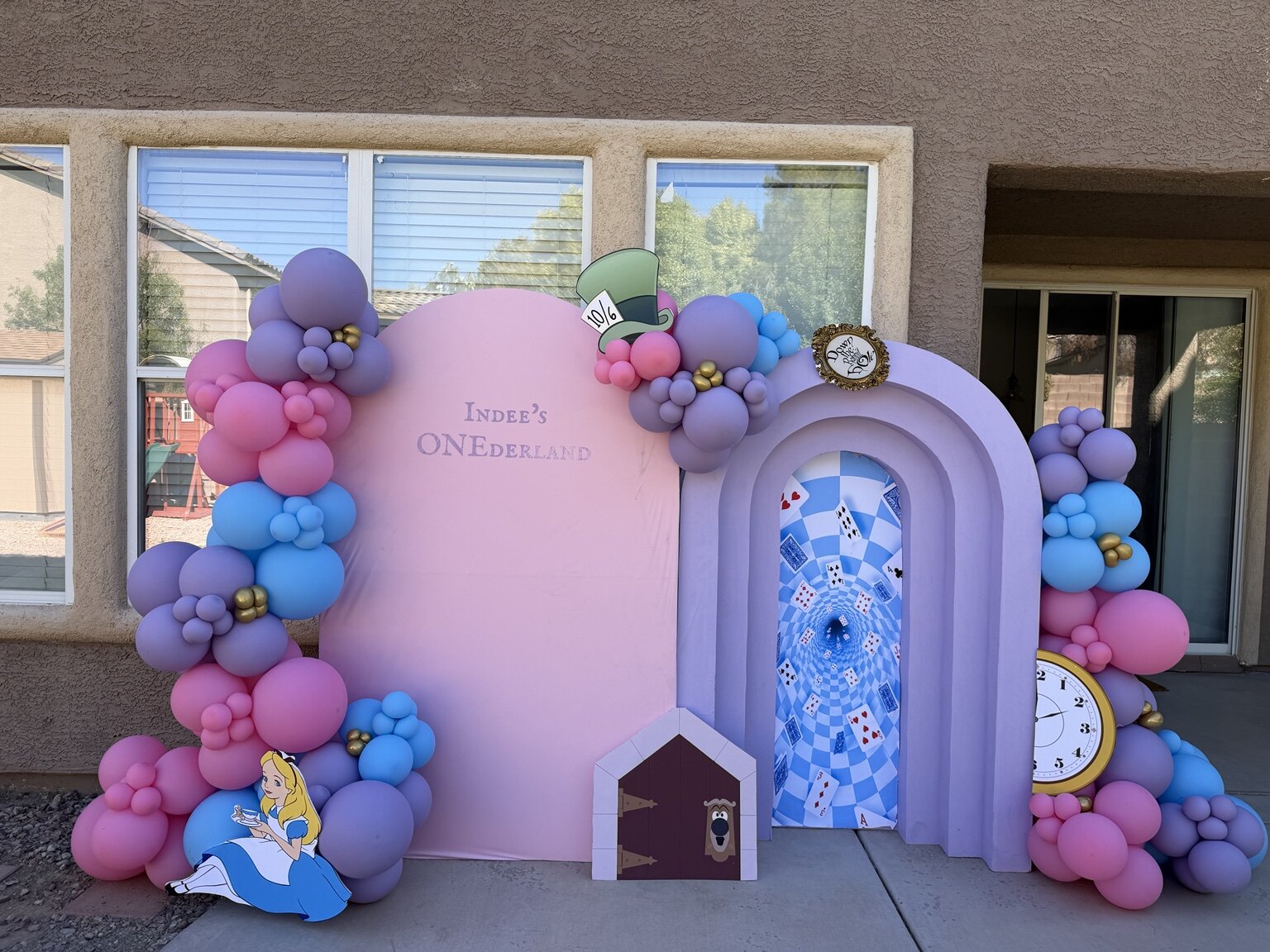 Indee’s Onederland first birthday backdrop with colorful balloons and Alice in Wonderland details